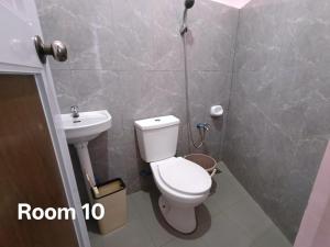a bathroom with a toilet and a sink at Glenmark's Homestay in Pagudpud