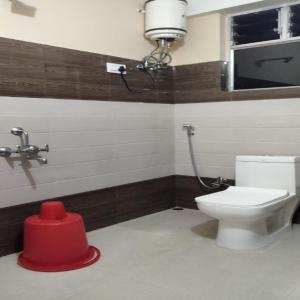 a bathroom with a toilet and a red object in it at Neel Pahari Homestay By StayApart in Pedong