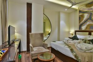 una camera da letto con un letto, una scrivania e uno specchio di HOTEL BR GRAND with NIMO CLUB ad Amritsar