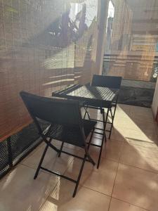 una mesa y sillas frente a una ventana en Charmant appartement, en Kani Keli