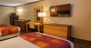 ein Hotelzimmer mit einem Schlafzimmer mit Schreibtisch und Fernseher in der Unterkunft Gated 2 Double Beds Studio with Full Kitchen 102 in Baton Rouge