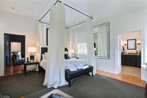 ein weißes Schlafzimmer mit einem Bett und ein Wohnzimmer in der Unterkunft Romancing The Jones in Savannah + 30 Fotos