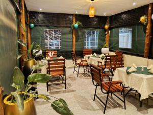 a restaurant with tables and chairs in a room at Petal Palace - Masindi in Masindi