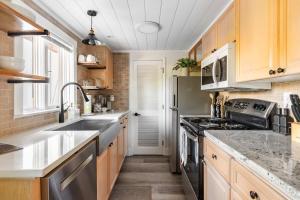 a kitchen with wooden cabinets and stainless steel appliances at Uptown 1 Bedroom Flat Near the Boise Train Depot in Boise