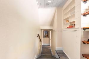 a hallway with white walls and wood floors at Uptown 1 Bedroom Flat Near the Boise Train Depot in Boise +18 photos