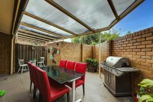 eine Terrasse mit einem Tisch, Stühlen und einem Grill in der Unterkunft Unley rd parkside Adelaide in Unley