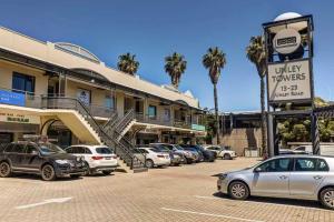 ein Parkplatz mit vor einem Gebäude geparkten Autos in der Unterkunft Unley rd parkside Adelaide in Unley