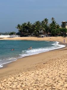 a group of people in the water at the beach at Villa 592A - Hikkaduwa in Hikkaduwa