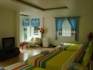 a living room with two beds and a television at Sea Beach Koh Larn 1 in Ko Larn