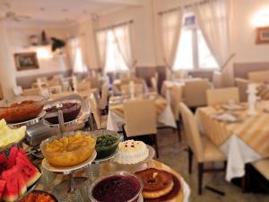 a room filled with tables with food on plates at Hotel Da Vinci in Serra Negra +21 photos