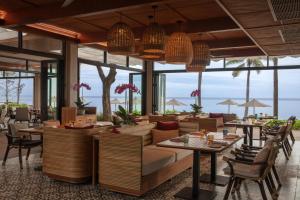 a restaurant with tables and chairs and windows at Anantara Hua Hin Resort in Hua Hin