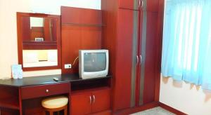 La salle de bains est pourvue d'un mur rouge et d'une télévision sur un comptoir. dans l'établissement Picnic Sriracha Hotel, à Ban Fang Daeng