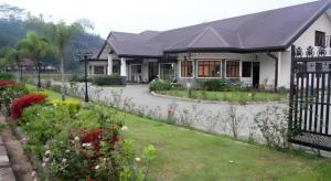 ein Haus mit einem Zaun vor einem Hof in der Unterkunft Talawakele Rest House in Talawakele