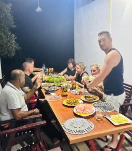 Eine Gruppe von Menschen, die an einem Tisch sitzen und Essen essen. in der Unterkunft Neem safari lodge Yala in Tissamaharama