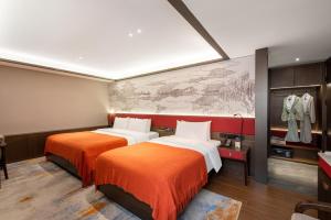 two beds in a hotel room with a map on the wall at Xi'an Jinshengdi Hotel, Datang Everbright City, Big Wild Goose Pagoda Branch in Xi'an