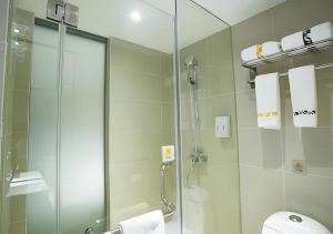 a bathroom with a shower and a glass shower stall at Jtour Inn Huanggang Wuxue City Square in Wuxue +110 photos