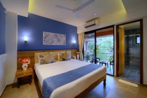 a bedroom with a large bed and a balcony at Foxoso Sonnet, Anjuna Goa in Anjuna