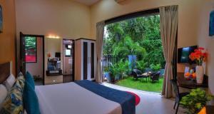 a bedroom with a bed and a large window at Foxoso Sonnet, Anjuna Goa in Anjuna