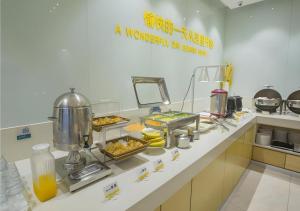 Eine Restaurantküche mit Speisen auf einer Theke in der Unterkunft City Comfort Inn Hechi Bama Shouxiang Avenue in Bama