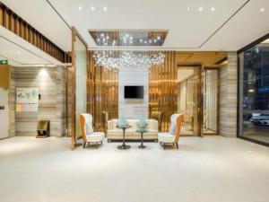 a lobby with a table and chairs and a chandelier at City Comfort Inn Guigang Hecheng Wanda Plaza in Guigang