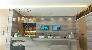 a woman sitting at a counter in a room at City Comfort Inn Guigang Hecheng Wanda Plaza in Guigang