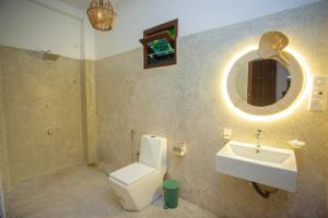 a bathroom with a sink and a toilet and a mirror at The Mud Crab 80 in Ahangama
