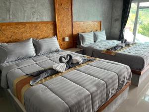 two beds in a room with towels on them at Phulanta Resort in Ko Lanta Yai