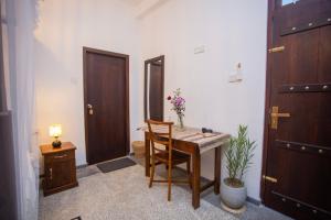 a room with a table and a chair and a door at The Mud Crab 80 in Ahangama