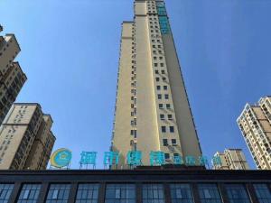 un grand bâtiment avec des chaises bleues devant lui dans l'établissement City Comfort Inn Suizhou Railway Station, à Suizhou