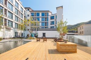 an outdoor deck with tables and chairs in front of a building at Huazhu Xiangshan Tongchen Courtyard in Xiangshan
