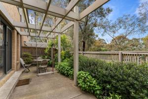 eine Pergola auf einer Terrasse mit einem Tisch und Stühlen in der Unterkunft The Pattern House Ballarat Lakeside Creative Haven in Eureka