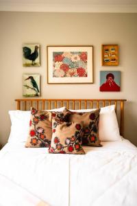 Schlafzimmer mit einem Bett mit Kissen und Bildern an der Wand in der Unterkunft The Pattern House Ballarat Lakeside Creative Haven in Eureka