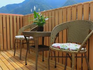 two wicker chairs and a table on a balcony at Vatica Hotel Huangshan South Gate Terminal Station in Huangshan Scenic Area