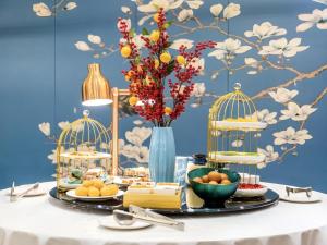 a table with food and birds cages on it at Gya Hotel Wuxi Hubin Commercial Street Tai Lake Scenic Area in Wuxi