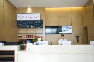 Ein Mann, der an einem Tresen in einem Restaurant sitzt. in der Unterkunft City Comfort Inn Huaihua East Station in Huaihua