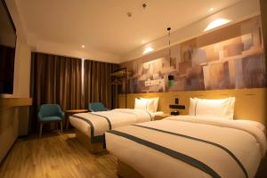 ein Hotelzimmer mit zwei Betten und einem Stuhl in der Unterkunft City Comfort Inn Huaihua East Station in Huaihua + 163 Fotos