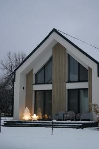 a house in the snow with tables and chairs at Harmonia Horyniec in Horyniec Zdrój