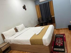 DispurTownhouse Lalmati National Highway 27 Formerly The Pinnacle Inn的房间里有一张大床的卧室