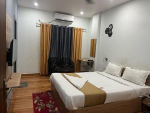 DispurTownhouse Lalmati National Highway 27 Formerly The Pinnacle Inn的一间带大床和电视的卧室