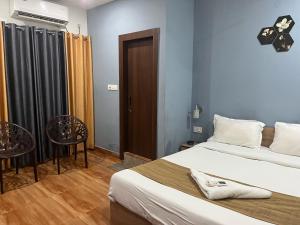 DispurTownhouse Lalmati National Highway 27 Formerly The Pinnacle Inn的一间卧室，有两张床、一张桌子和几把椅子