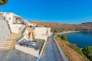 a white house with a view of a lake at Lindos Shore Superior Studio in Lindos
