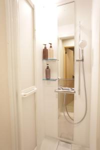 a shower with a glass door in a bathroom at Kimono Hotel Himeji 着物宿 in Himeji +45 photos