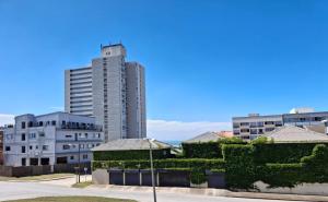 a tall building in the middle of a city at The Ocean Nook - Modern Beach Condo in Gqeberha