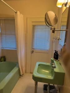 ユージンにある5BR Gated Parking Historic Homeのバスルーム(緑のシンク、鏡付)