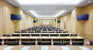 an empty lecture hall with bottles on the tables at Vienna Hotel Anhui Guangde Development Zone in Guangde