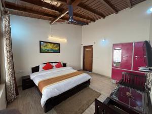 a bedroom with a large bed with red pillows at Hotel Goludev Valley View in Nainital