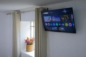 a flat screen tv hanging on a wall next to a window at Xaxa Lodge in Tarma