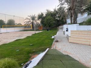 a park with a fence and a field of grass at Project ADAM in Ras al Khaimah