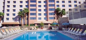 un hotel con piscina con sillas y un edificio en The Carriage House, en Las Vegas