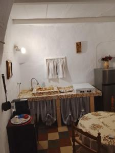 eine Küche mit Theke und Tisch in einem Raum in der Unterkunft Il trullo della nonna in Martina Franca